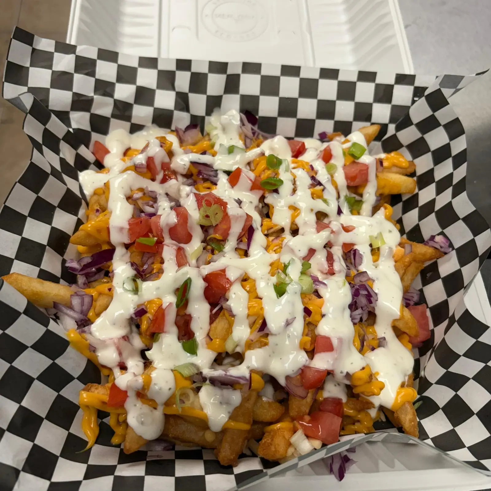 Loaded fries topped with cheese, bacon, and sauces at Wing Crafters in London, ON